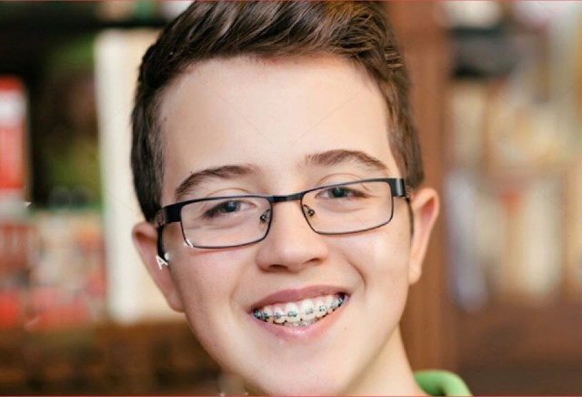 Chłopiec z aparatem ortodontycznym do świątecznej reklamy tv